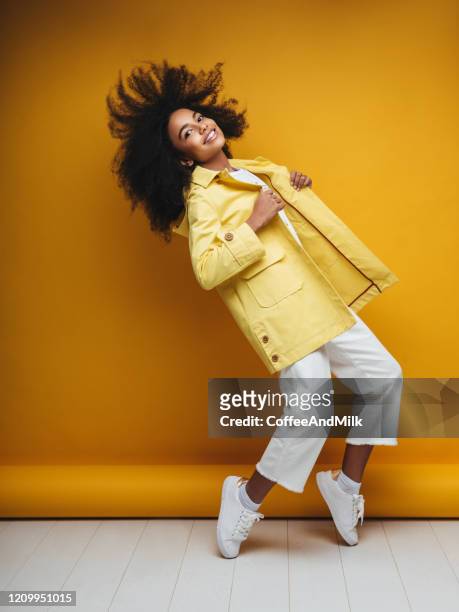 jonge vrouw die regenjas draagt - cool attitude stockfoto's en -beelden