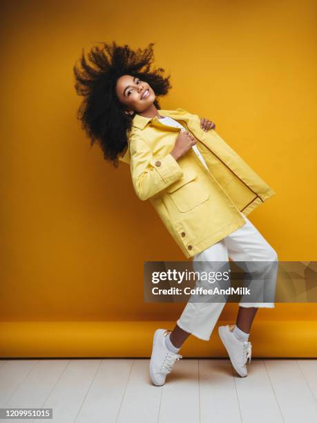 young woman wearing raincoat - blazer amarelo imagens e fotografias de stock