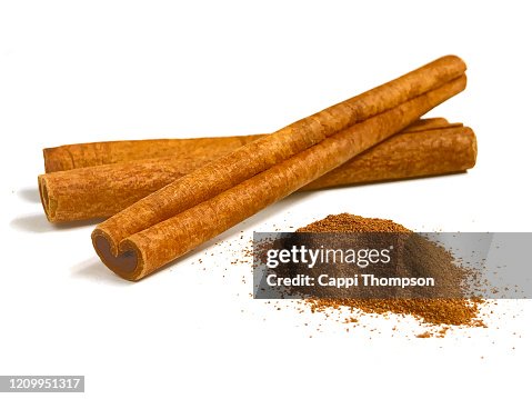 Cinnamon sticks and ground cinnamon over white background Cinnamon sticks and ground cinnamon over white background