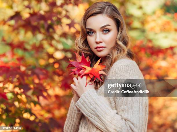 pretty young girl holds autumn bouquet in her hands - beautiful woman fall stock pictures, royalty-free photos & images