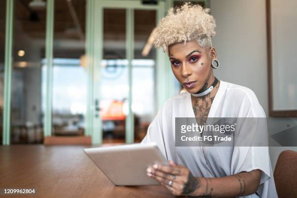 verticale de femme d’affaires tatouée utilisant la tablette numérique au travail - tatouage femme photos et images de collection