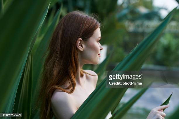 cute woman in the park enjoys life and watches the sunset - fashion swimwear stock pictures, royalty-free photos & images