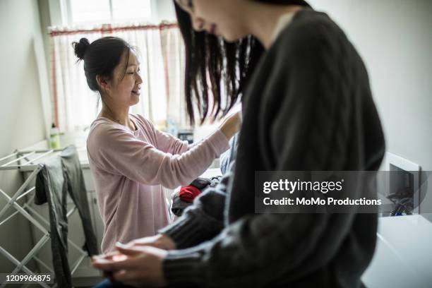 teenage girl talking with mother in laundry room - family with one child mother bonding family adult daughter focus on background leisure stock-fotos und bilder
