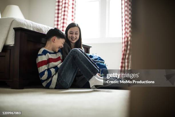 brother and sister laughing in bedroom at home - teens brothers stock-fotos und bilder