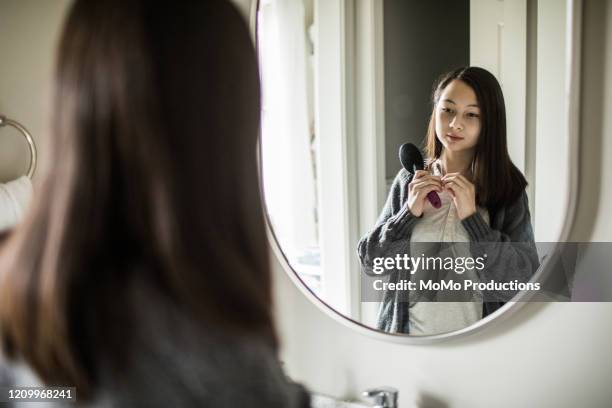teenage girl brushing her hair in mirror - preocupación por el cuerpo fotografías e imágenes de stock