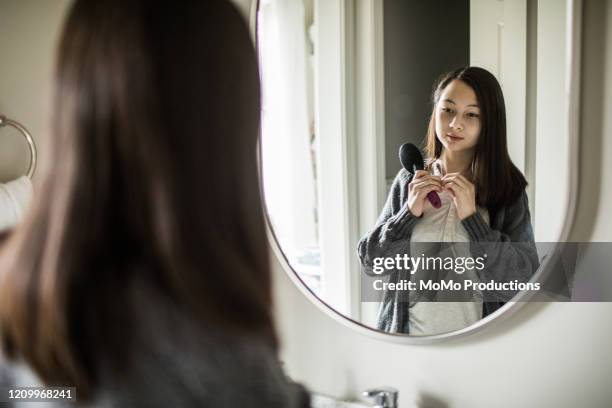 teenage girl brushing her hair in mirror - backstage mirror stock pictures, royalty-free photos & images