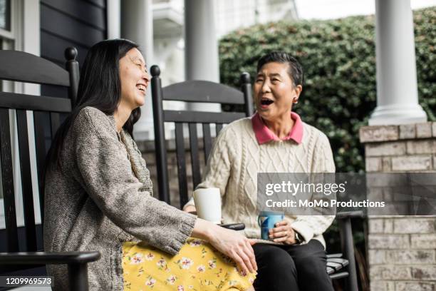 adult woman and senior mother talking on front porch - hand on knee stock pictures, royalty-free photos & images
