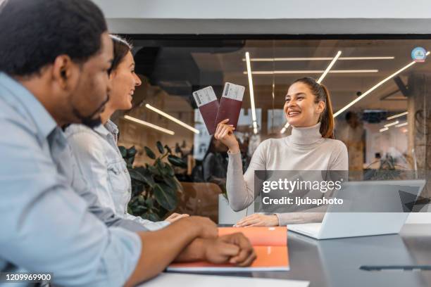 coppia seduta con il manager presso l'ufficio dell'agenzia di viaggi e revisione del contratto - agency foto e immagini stock