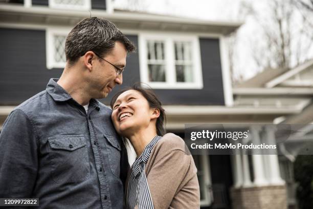 couple standing in front of home - wealth advisor stock pictures, royalty-free photos & images