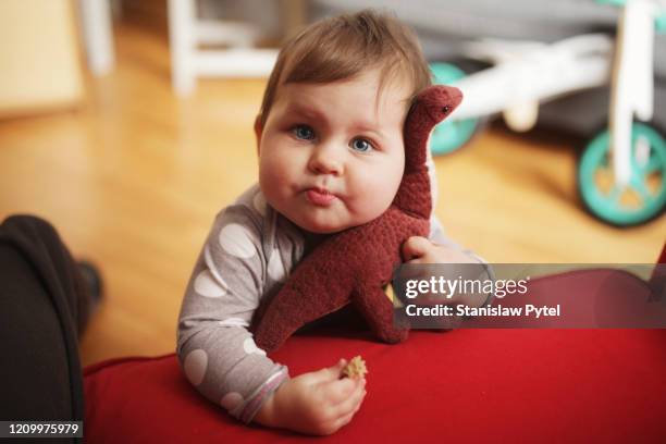 kid huging plush toy and eating at home - baby eating toy stock pictures, royalty-free photos & images