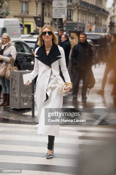 Lisa Aiken wearing white coat with black collar, black pants, Ray-ban sunglasses and zebra print shoes outside Giambattista Valli during Paris...