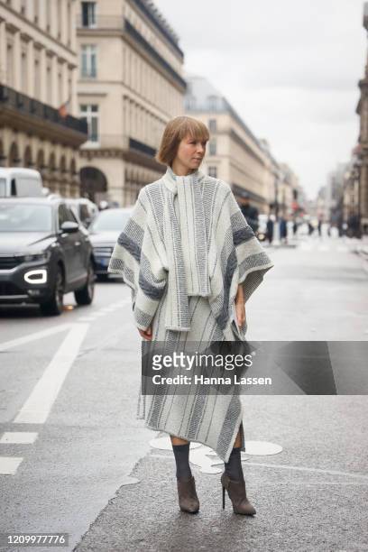 Guest wearing poncho knit jumper and skirt outside Giambattista Valli during Paris Fashion Week Womenswear Fall/Winter 2020/2021 Day Eight on March...