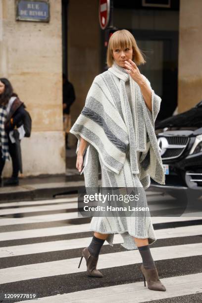 Guest wearing poncho knit jumper and skirt outside Giambattista Valli during Paris Fashion Week Womenswear Fall/Winter 2020/2021 Day Eight on March...