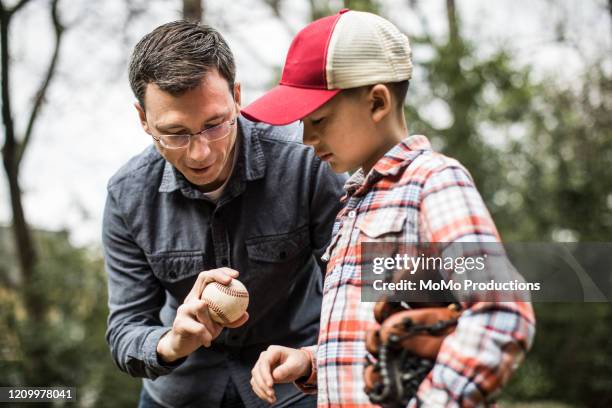 father teaching son to throw a baseball - young baseball pitcher stock pictures, royalty-free photos & images