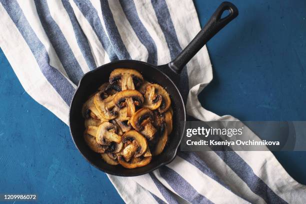 fried mushrooms in a vintage pan with fresh herbs - fried stock pictures, royalty-free photos & images