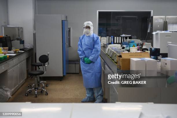This photo taken on April 10, 2020 shows a technician in a sample mixing lab at CapitalBio Technology, a Beijing-based company which makes medical...