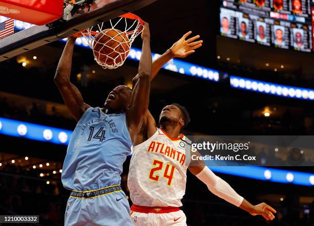 Gorgui Dieng of the Memphis Grizzlies dunks against Bruno Fernando of the Atlanta Hawks in the second half at State Farm Arena on March 02, 2020 in...