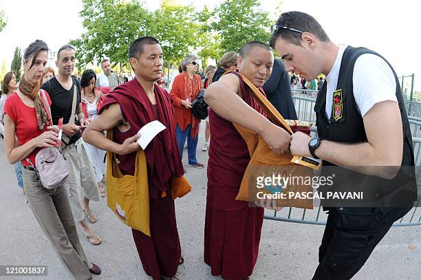 Visitors present their bags to be checked prior to attend a conference of the Dalai Lama, the Tibet's exiled spiritual leader on August 13, 2011 at...