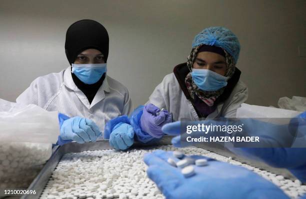 Palestinian employees prepare a nutritional supplement made with vitamin C and Zinc to help strength the body's immunity against the coronavirus...