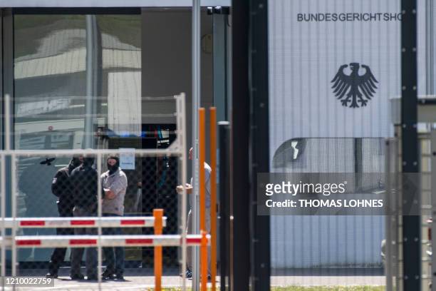 Masked policemen are seen on the grounds of the Federal Supreme Court in Karlsruhe, southern Germany, on April 15 after five Tajiks suspected to be...