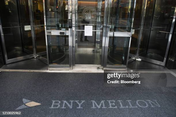 Bank of New York Mellon Corp. Signage is displayed on a carpet outside an office building in New York York, U.S., on Saturday, April 11, 2020. Bank...