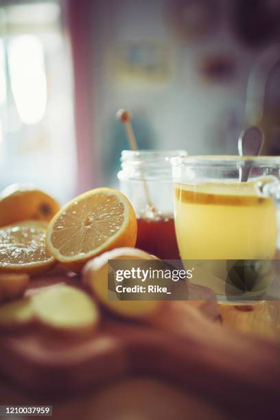 fresh hot lemon with ginger prepared in a pretty country house kitchen - honey lemon stock pictures, royalty-free photos & images