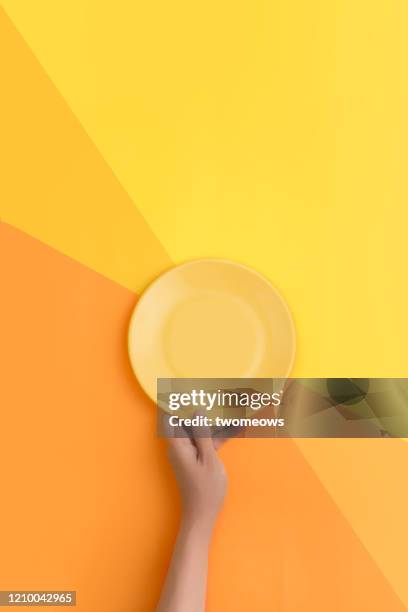 yellow empty plate text space image. - plate in hand stockfoto's en -beelden