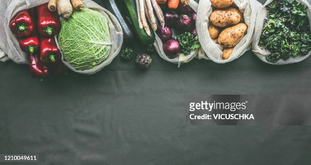 variety of vegetables in eco friendly bags on dark background - food flatlay stock-fotos und bilder