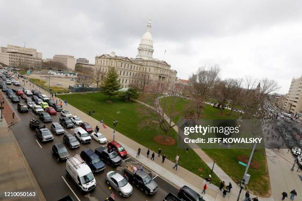 People in their vehicles protest against excessive quarantine orders from Michigan Governor Gretchen Whitmer around the Michigan State Capitol in...