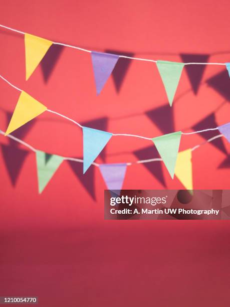 colourful bunting casting shadows on a pink background - bunting stock pictures, royalty-free photos & images