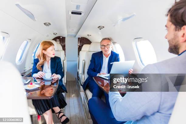 business people traveling by corporate jet - rich people stock pictures, royalty-free photos & images