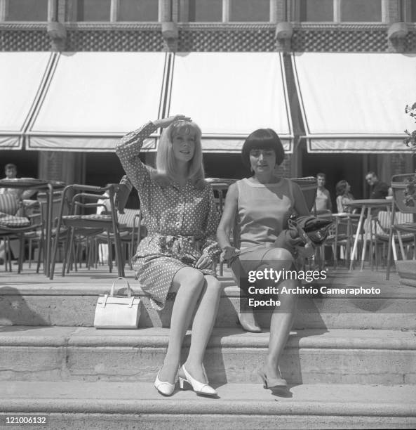 French actress Catherine Deneuve, wearing a polka-dotted dress, portrayed while sitting on the Excelsior Hotel's stairs with the director Agnes...