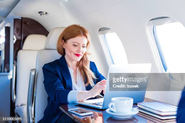 geschäftsfrau mit dem firmenjet unterwegs - business jet stock-fotos und bilder