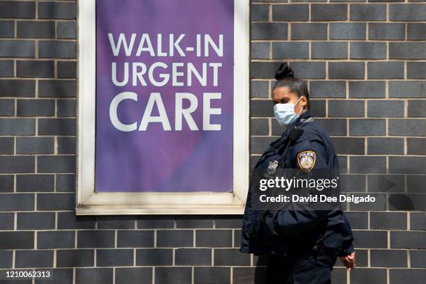 Hospital security guard wears a medical mask outside of Elmhurst Medical Center on April 15 in Queens borough of New York City.During his daily...