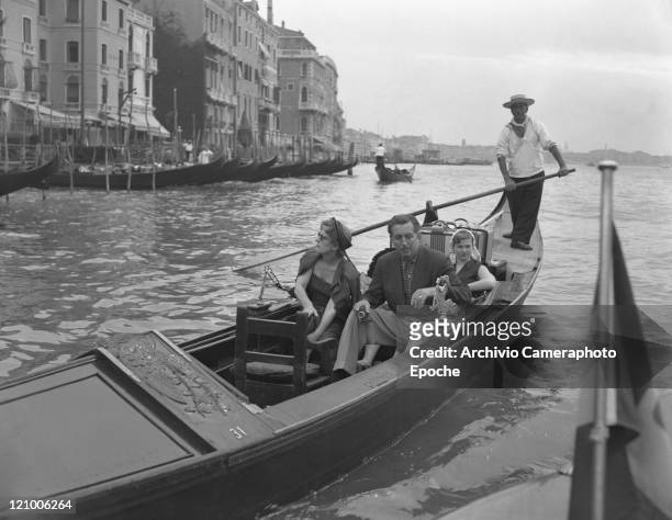 American director Walt Disney, holding a camera, portrayed sitting on a gondola with the family, his wife Lillian and his daughters Diane Marie and...