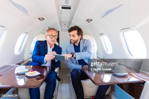 zwei geschäftsleute mit dem firmenjet unterwegs - business jet stock-fotos und bilder