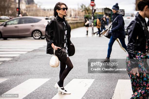 Chloe Harrouche, wearing a floral print mini dress, black leather jacket, pearl bag and white shoes, is seen outside Paco Rabanne, during Paris...