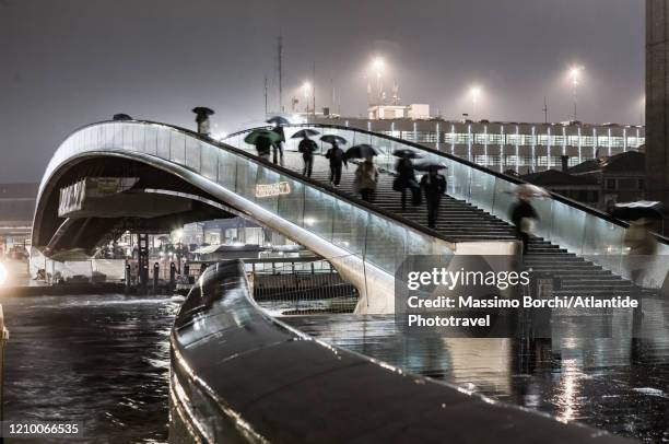 people with umbrellas crossing ponte della costituzione in a rainy night - santiago calatrava 個照片及圖片檔