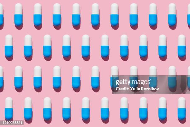 repeated pills on pink background - ripetizione foto e immagini stock