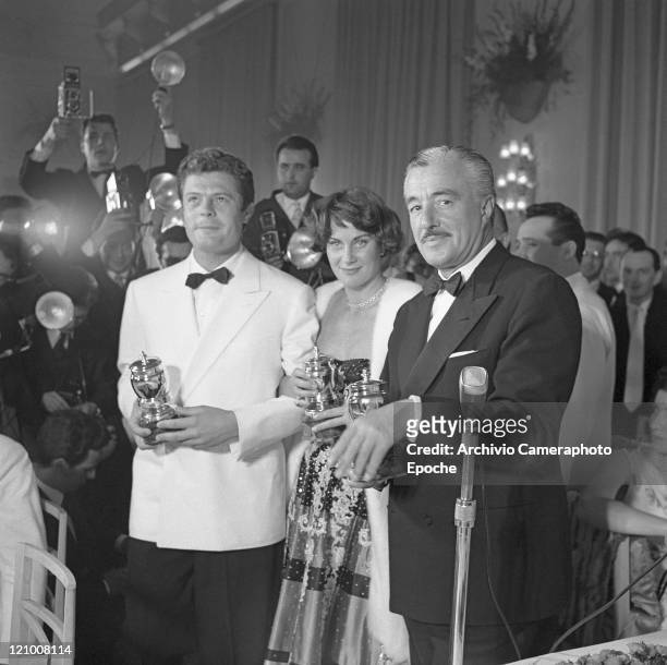 Italian actor Vittorio De Sica, wearing a tuxedo and a bow tie, portraiyed with Alida Valli and Marcello Mastroianni during the St. Vincent...