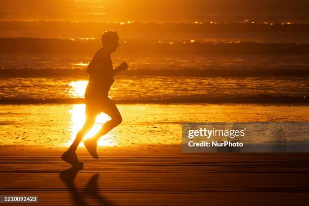 An elderly man jogs at empty New Brighton beach in Christchurch, New Zealand, on April 16, 2020. New Zealand is currently in alert level four. The...