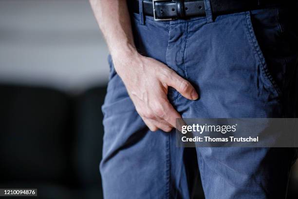 Symbol image venereal disease or bladder weakness. A man grabs his crotch with his hand on April 13, 2020 in Berlin, Germany.