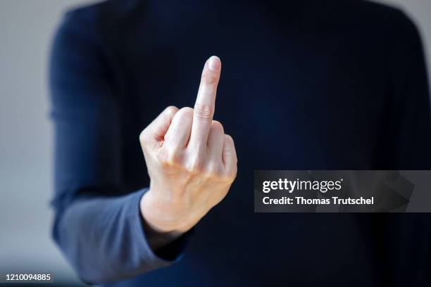 Symbolic photograph. A woman points her middle finger into the camera on April 13, 2020 in Berlin, Germany.