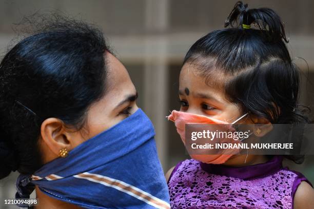 Mother chats with her daughter while standing in a queue to get tested for the the COVID-19 coronavirus inside Dharavi slums during a...