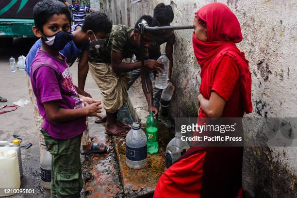 Local people wearing masks to collect drinking water from the tap of WASA as they don't get fresh drinking water at home. When they collect the water...