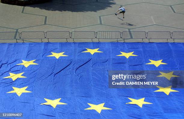 Un jeune skater joue le 09 mai 2001, journée de l'Europe près du drapeau européen de 600 m2 posé sur le parvis de l'université Robert Schuman à...