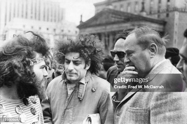 American political and social activists Jerry Rubin and Abbie Hoffman talk with unidentified others on a street, New York, New York, March 22, 1969.