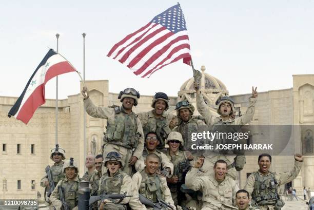 Marines wave US and Iraqi flags 14 April 2003 in front of al-Faruq Palace in the city of Tikrit, toppled iraqi President Saddam Hussein's hometown,...