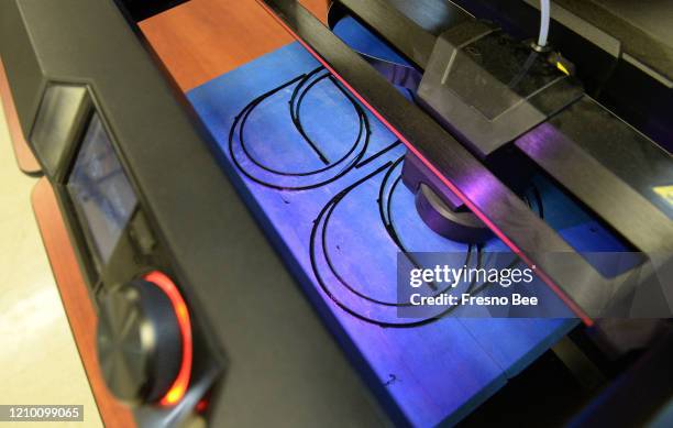 El miércoles 8 de abril de 2020, una impresora 3D produce correas plásticas para la cabeza en la secundaria Charter de Educación Técnica Profesional...