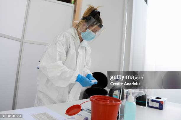 Health worker wearing a protective medical equipment extracts blood from a patient to make an antibody test for COVID-19 at the Dworska Hospital in...